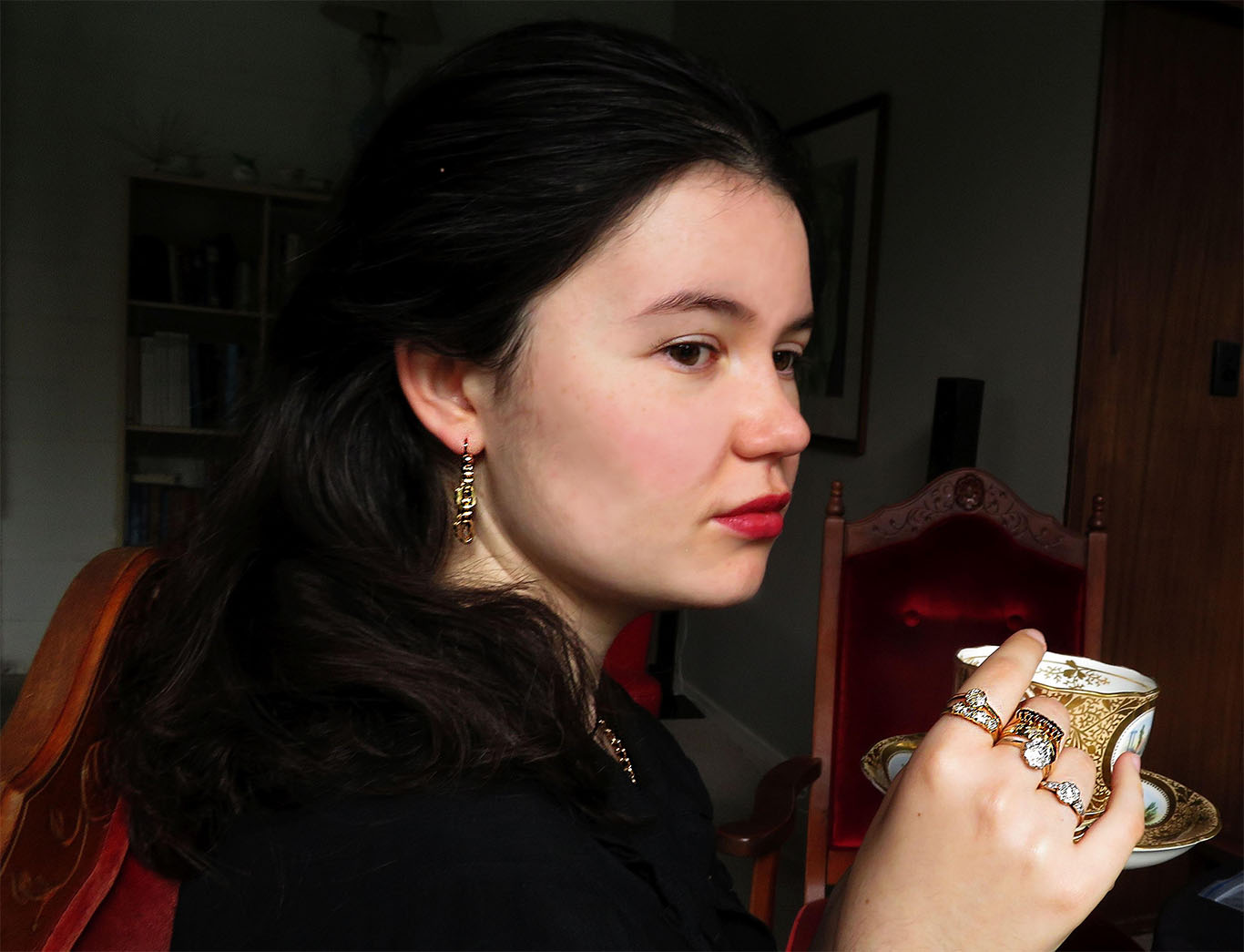 Victorian era lady drinking tea, wearing jewellery